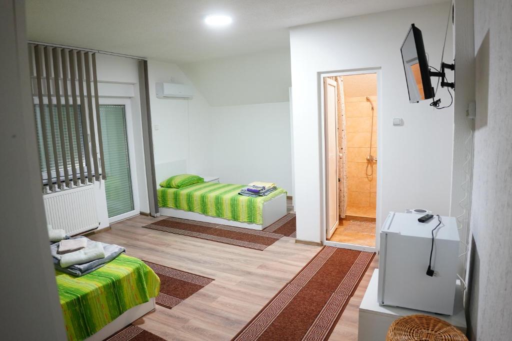 克拉多沃Rooms Busujok的一间设有床铺和电视的房间