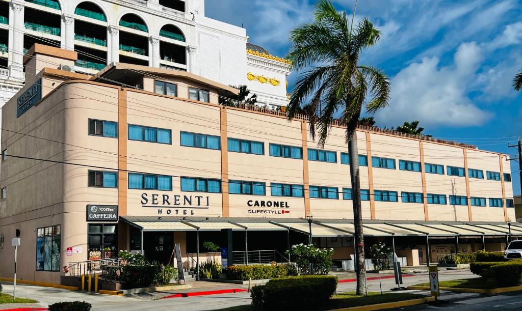 加拉班塞班岛塞伦蒂酒店的前面有棕榈树的建筑