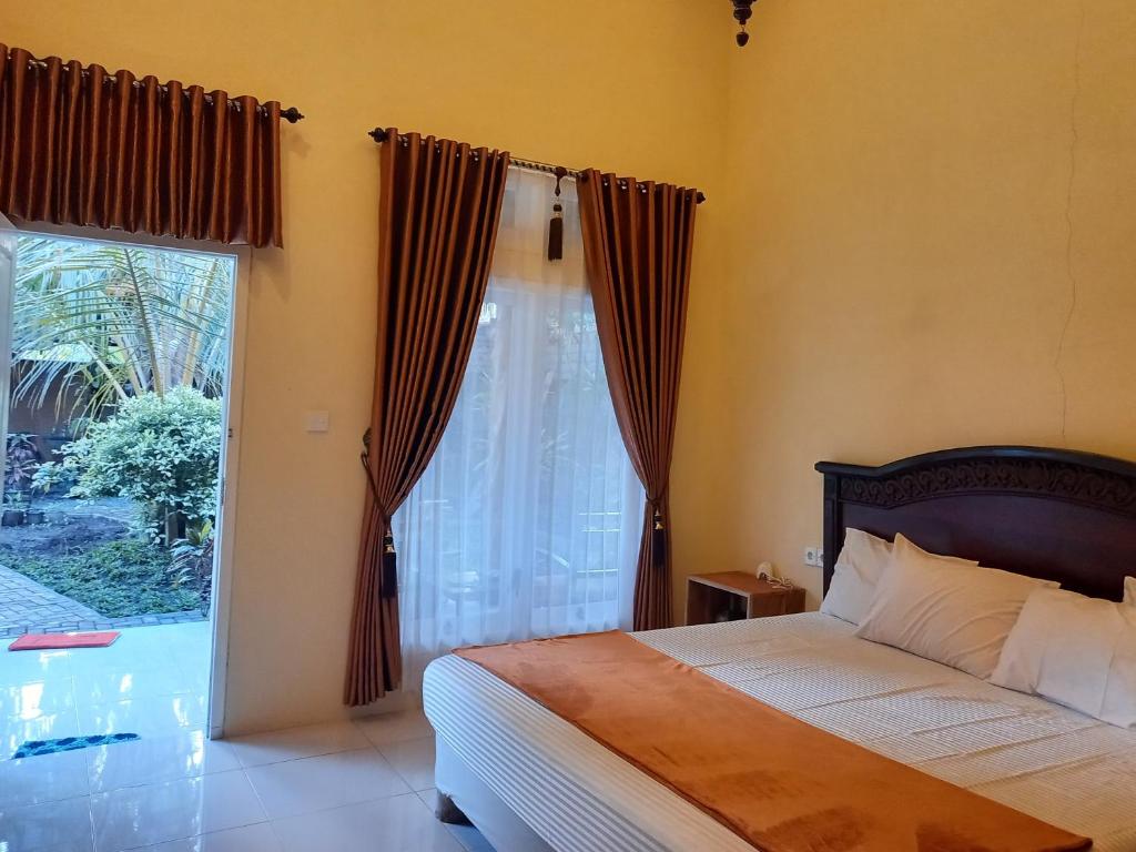 外南梦TelukBiru Homestay的一间卧室设有一张床和一个大窗户