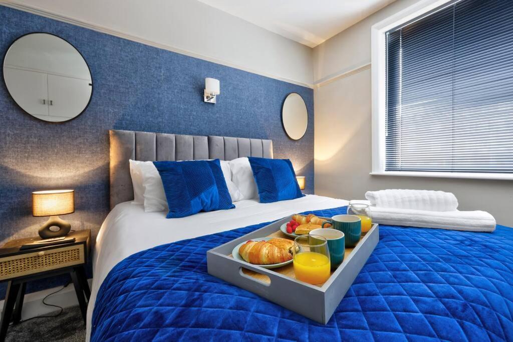 BareDeluxe king seaside apartment的一间卧室配有一张床,上面放着一个食物托盘