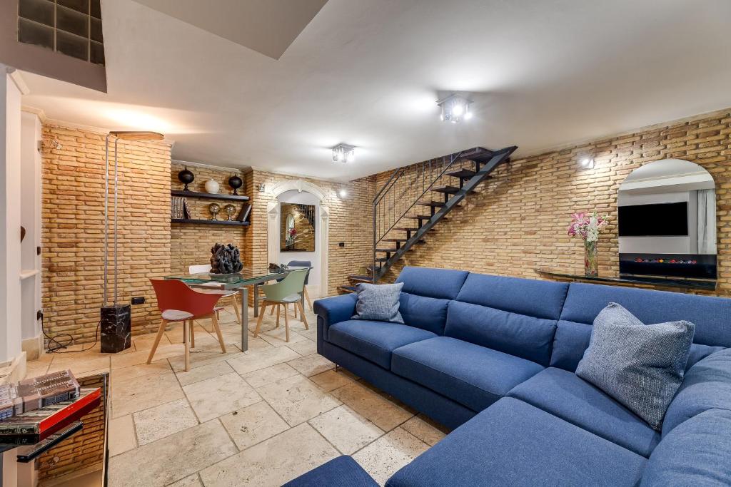 罗马Oliviero - Piazza Navona Apartment的客厅设有蓝色的沙发和砖墙