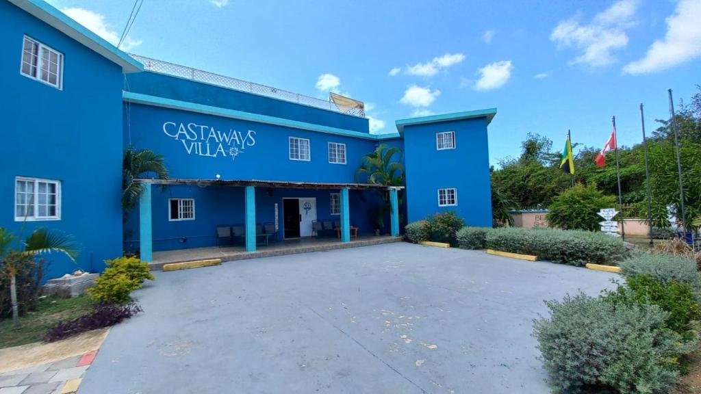 DuncansCastaways Villa的蓝色的建筑,前面设有停车场