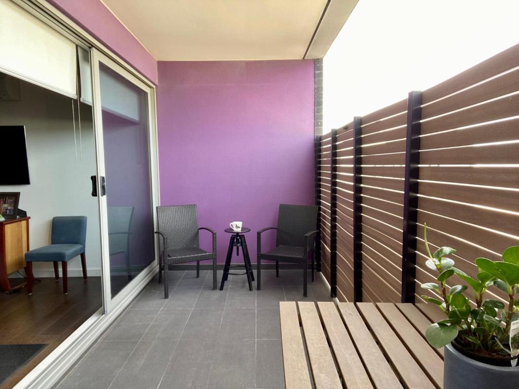 阿斯彭达尔Beach Life的阳台配有椅子和紫色墙壁