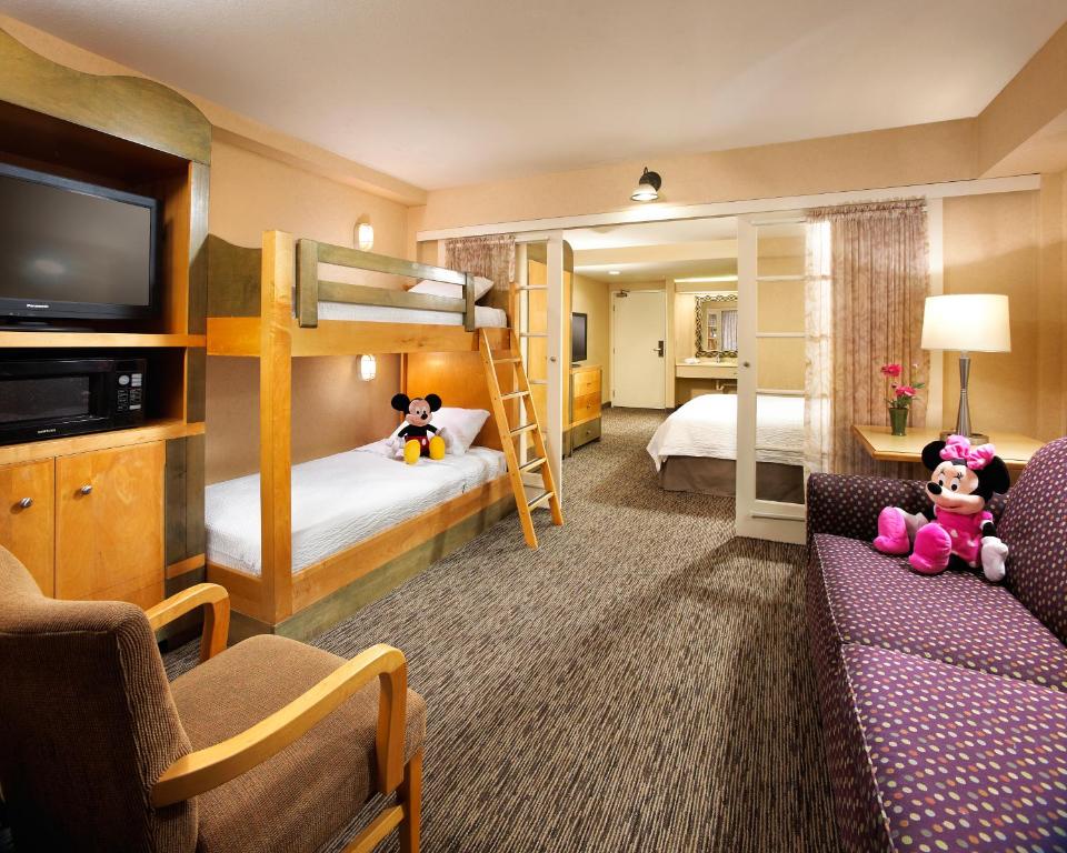 安纳海姆阿纳海姆酒店波托菲诺套房酒店的酒店客房设有两张双层床和一张沙发。