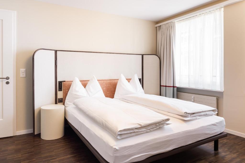 苏黎世EMA House Serviced Apartments Superior Seefeld的一间卧室设有两张带白色床单的床和窗户。