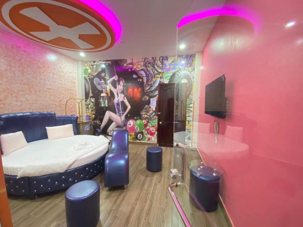 胡志明市HOTEL THU HÀ的卧室配有一张床,墙上挂有绘画作品
