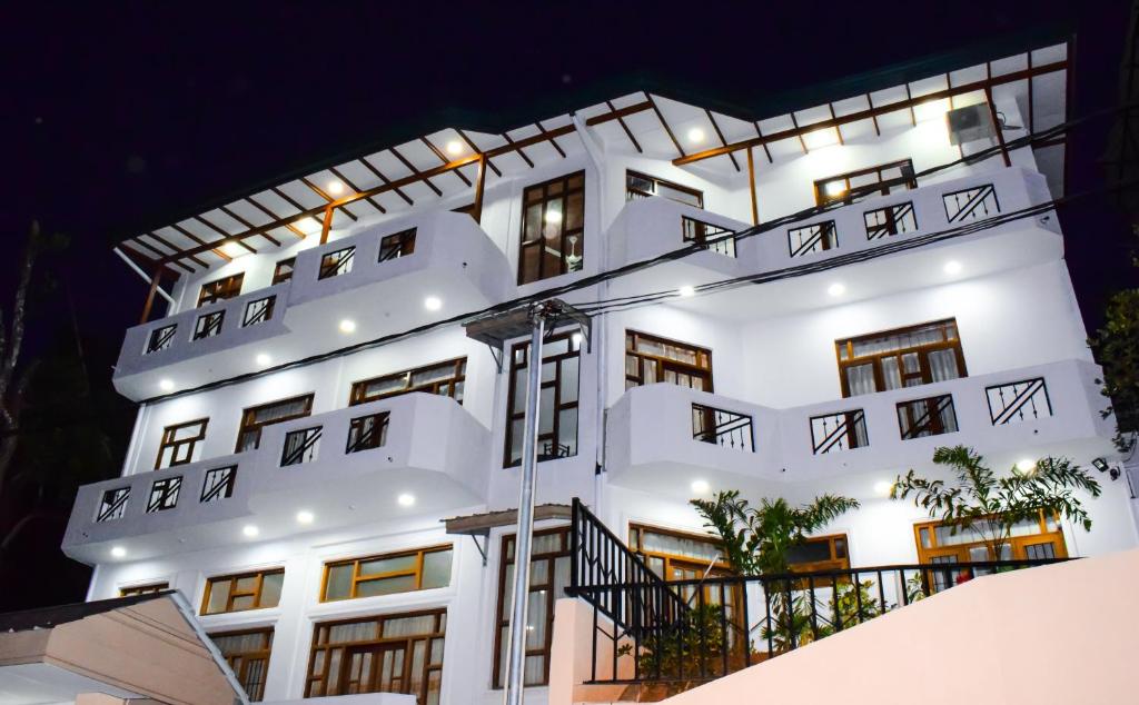 康提SaRu Holiday Apartment - Upto 6 Guests的白色的建筑,晚上有灯