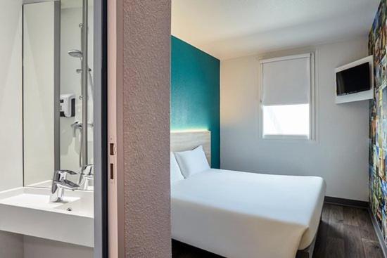 圣洛HOTEL F1 SAINT-LO的浴室设有白色的床和水槽。