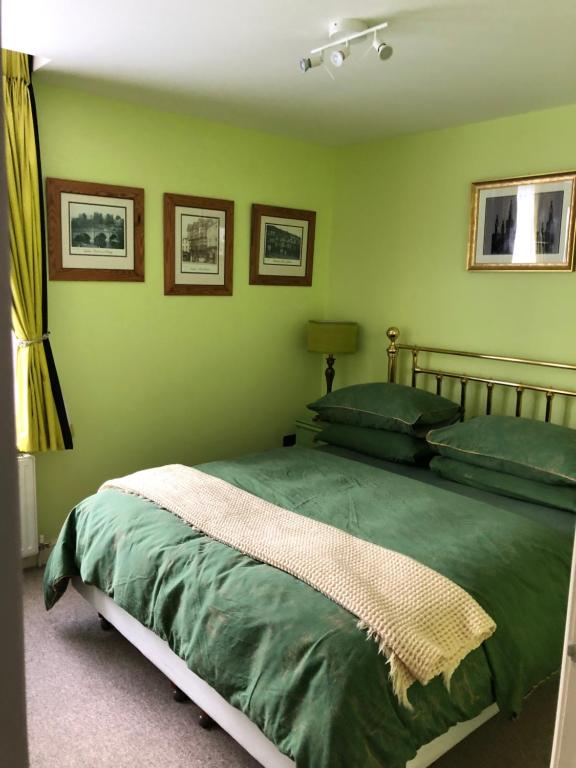 勒德洛Flat G, 8 Castle Street的一间卧室设有一张带绿色墙壁的床