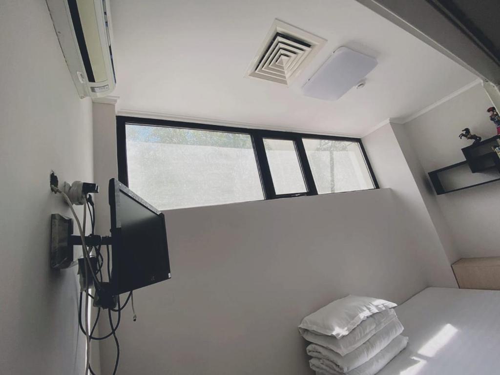 阿斯塔纳Hotel Kapsula的小房间配有电视和带毛巾的床