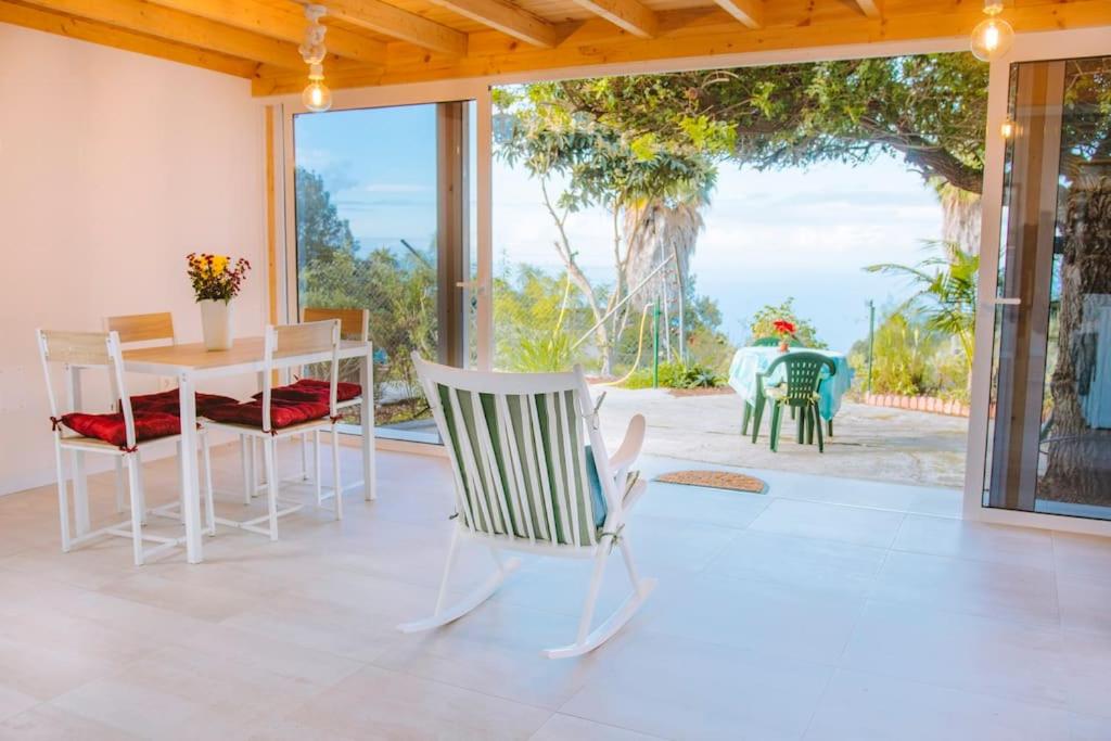 伊科德洛斯维诺斯Casita Gopal的一间带桌椅的客厅和一个庭院