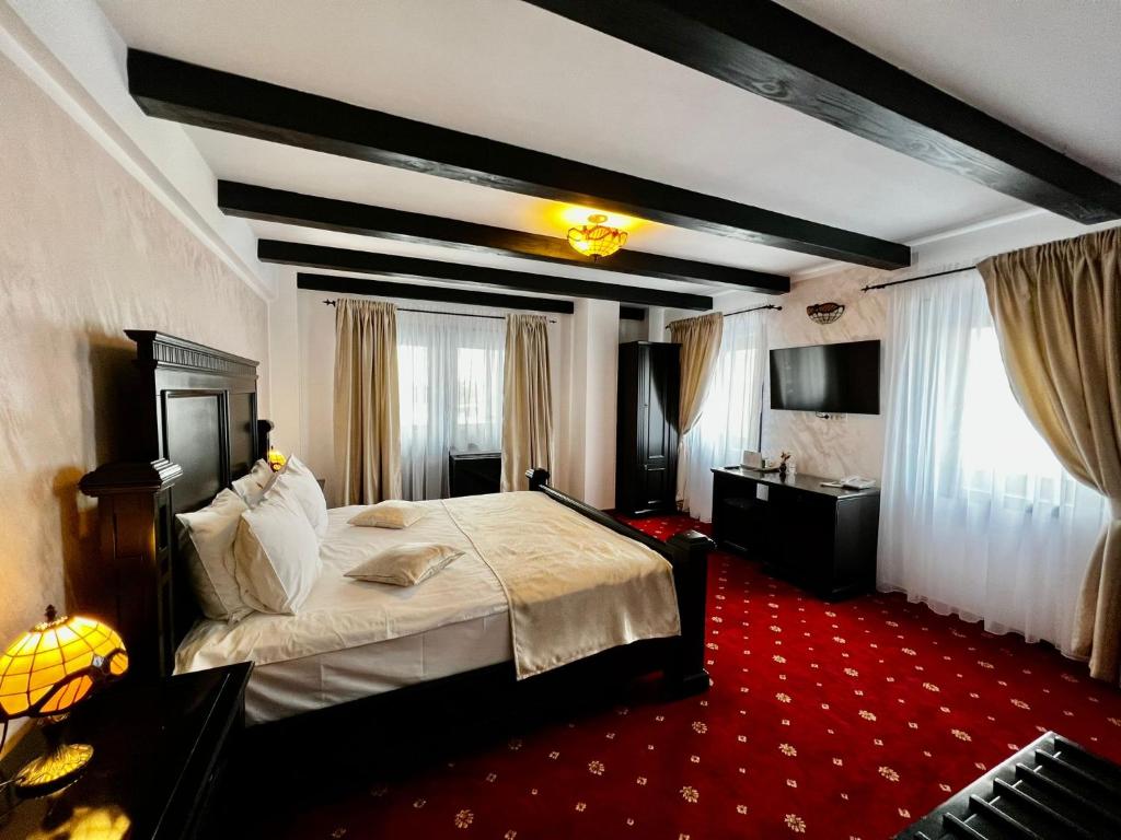 巴克乌Podu' cu Lanturi的一间卧室配有一张大床和红地毯