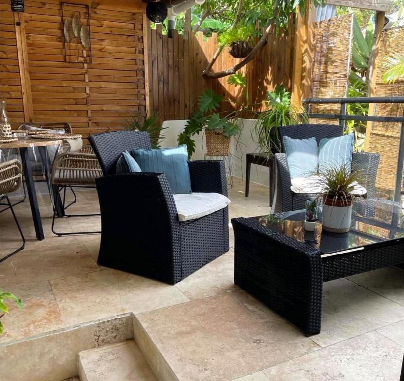 圣勒OSun Bungalow的庭院设有藤椅和咖啡桌