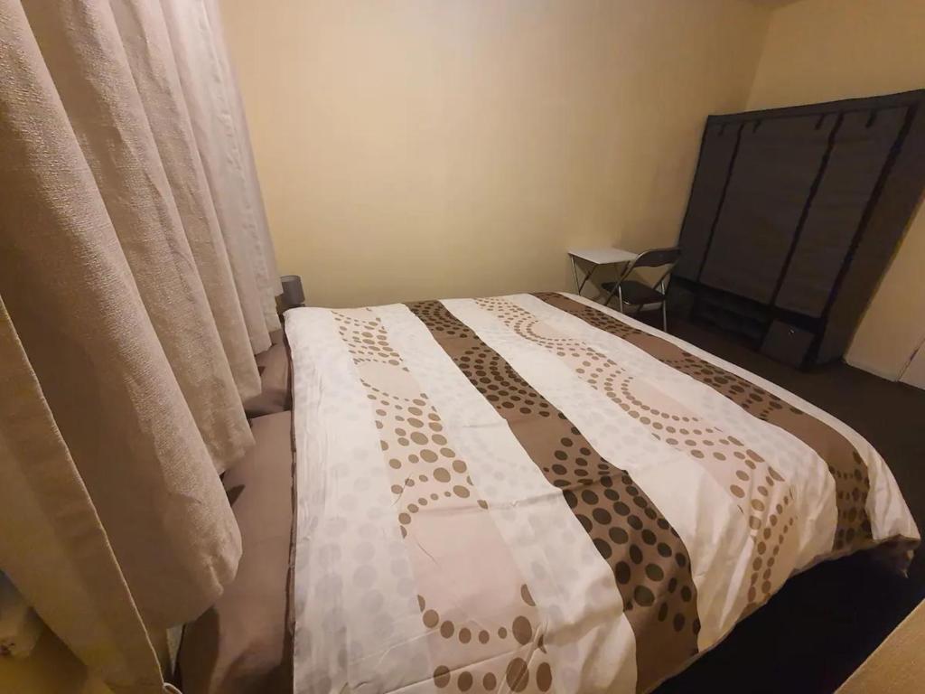 米德尔顿Spacious Double Bedroom Manchester的一间卧室配有一张带床罩和窗帘的床