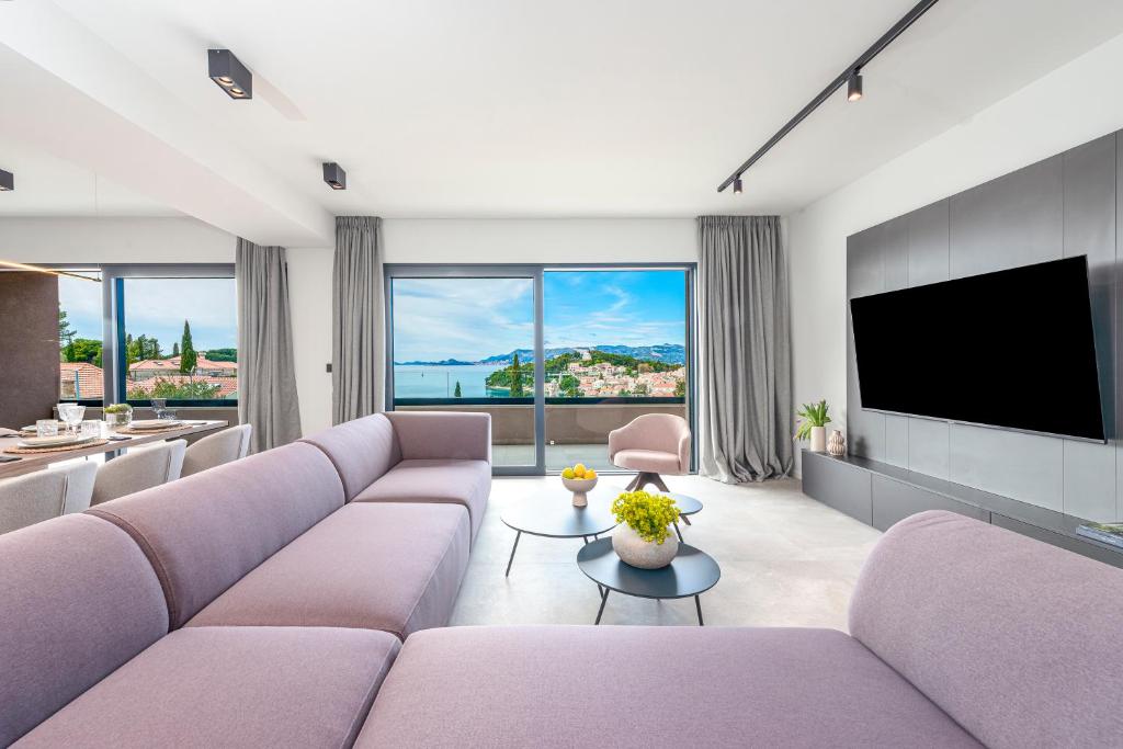 察夫塔特"Villa AnMari" The Cavtat View Residence的客厅配有紫色家具和平面电视。