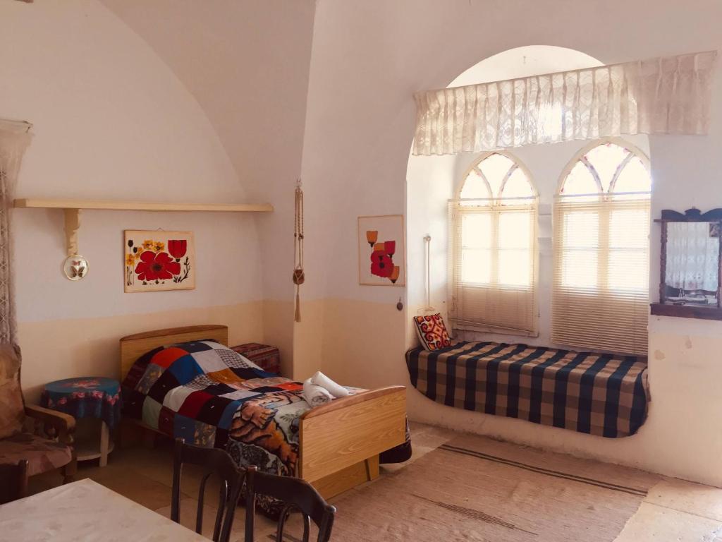 伯利恒Traditional House with Amazing Veranda的一间卧室设有两张床和窗户。