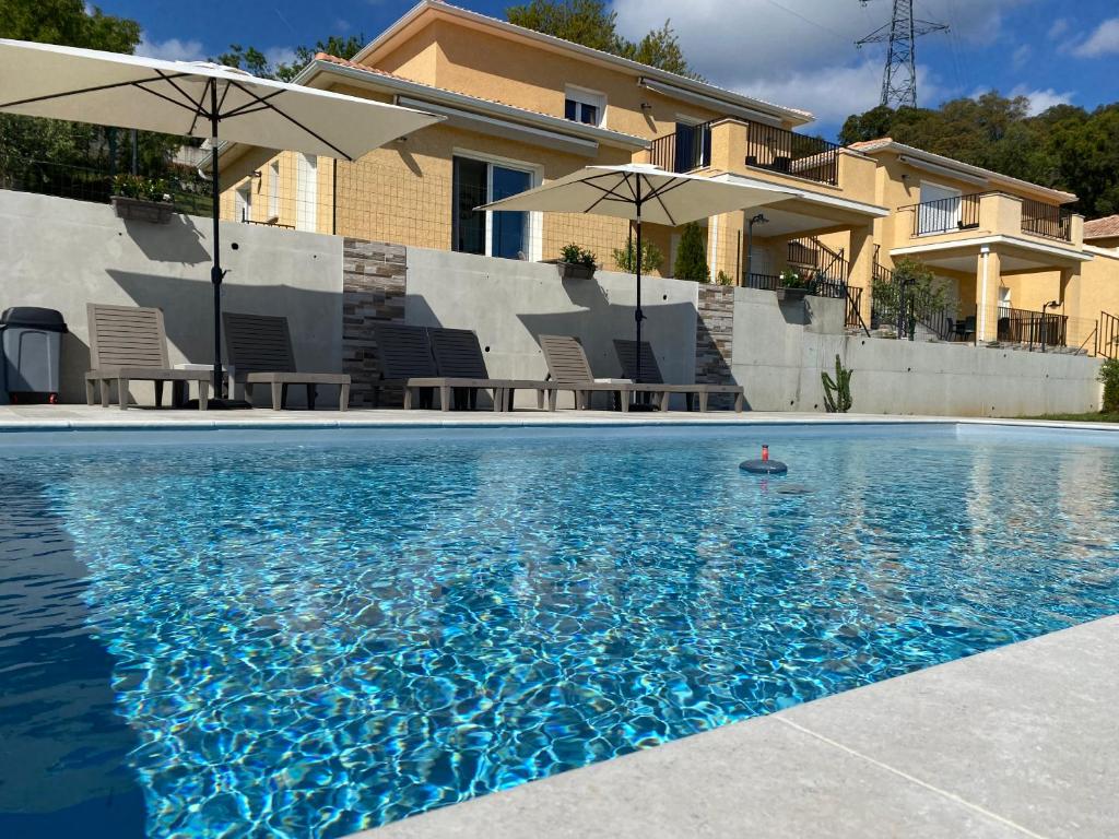 巴斯蒂亚Résidence Pasturella的房屋前的带遮阳伞的游泳池