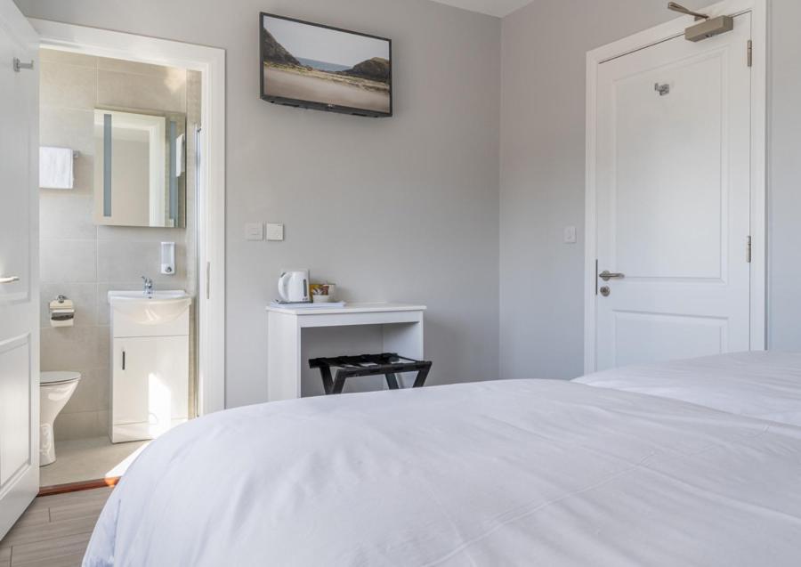 沃特福德Brownstown Head Room 4的白色卧室配有白色的床和浴室