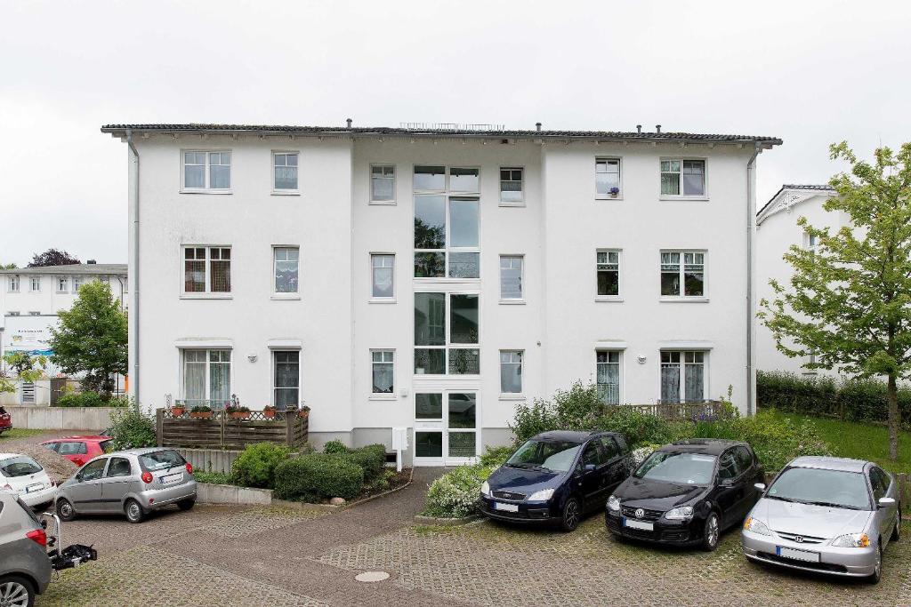 奥斯特巴德·哥伦Appartement Granitz - Ferienwohnung Thoenissen的一座白色的房子,前面有汽车停放