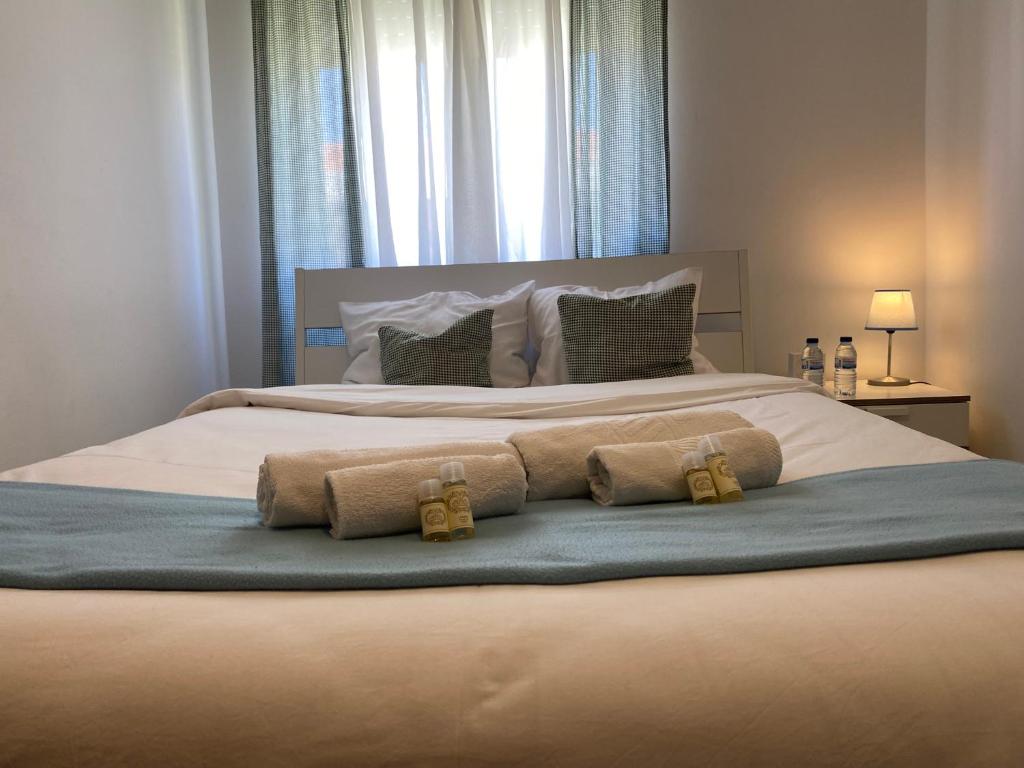 巴雷鲁Barreiro Central Apartment的一间卧室配有一张大床和两条毛巾