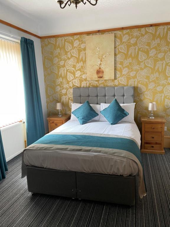 因弗内斯Inchrye Bed & Breakfast的一间卧室配有一张带蓝色枕头的大床