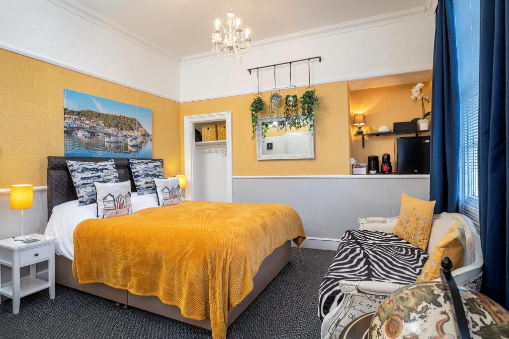斯卡伯勒Glenholme Guest House - Room Only的卧室拥有黄色的墙壁,配有一张床和椅子