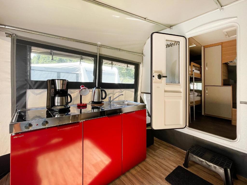 黑灵斯多夫Mietwohnwagen 01的红色橱柜里的厨房