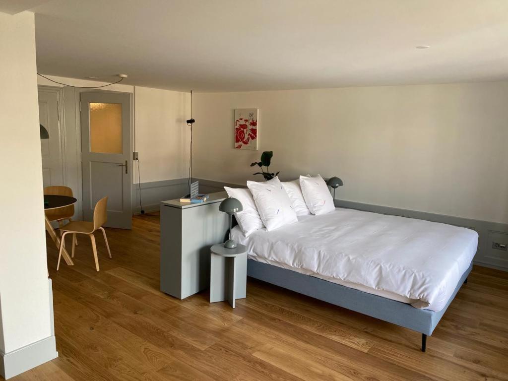 弗里堡La Sauvage的一间卧室配有带白色床单和白色枕头的床。