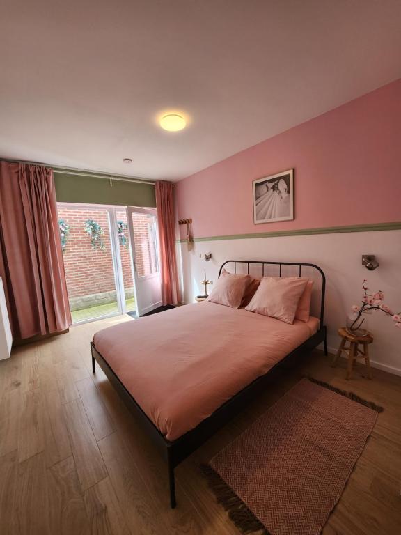 NijswillerBed & Stay Kersenbloesem的一间卧室配有一张粉红色的墙壁和窗户。