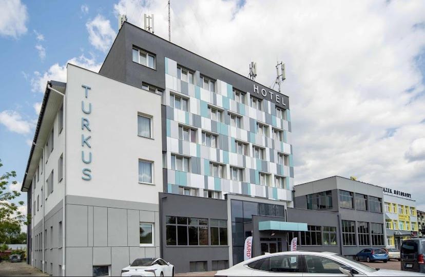 比亚韦斯托克Hotel Turkus的前面有停车场的酒店