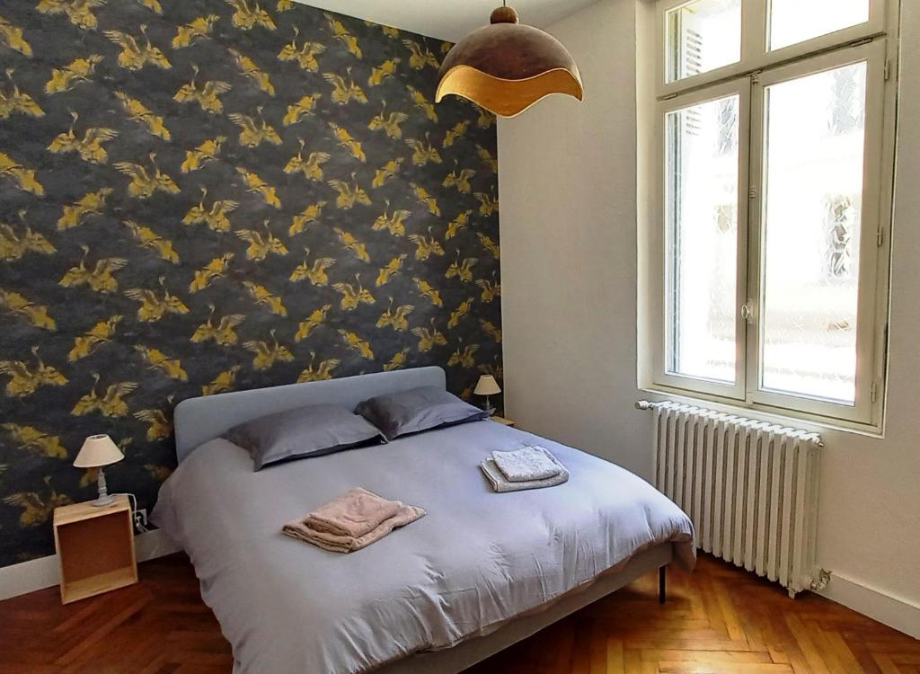 索米尔Histoire de Loire : GABRIELLE的一间卧室配有一张带花卉图案墙壁的床