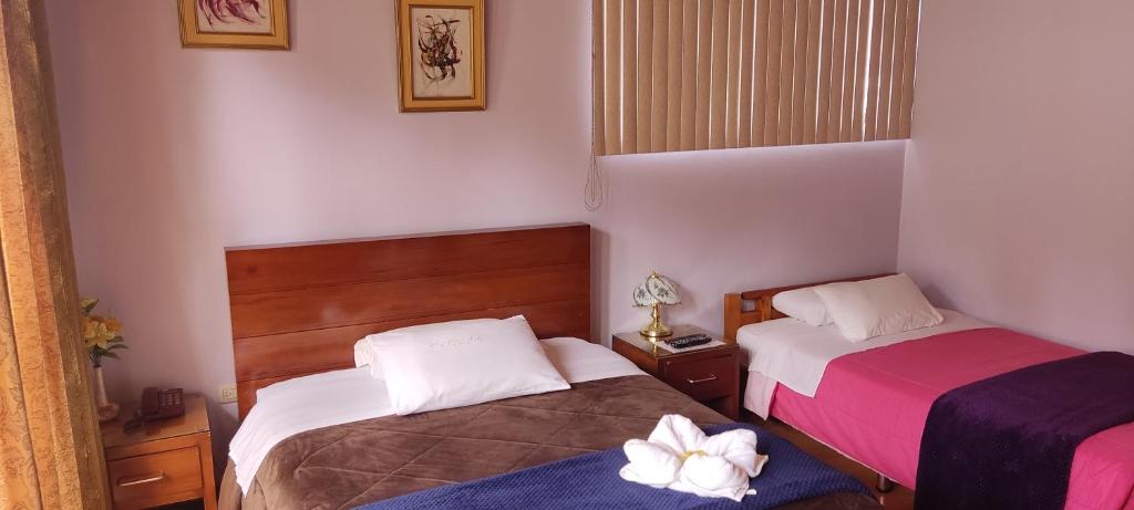 昆卡Hotel G&G的配有2张位于小客房内的床铺,配有粉红色和紫色