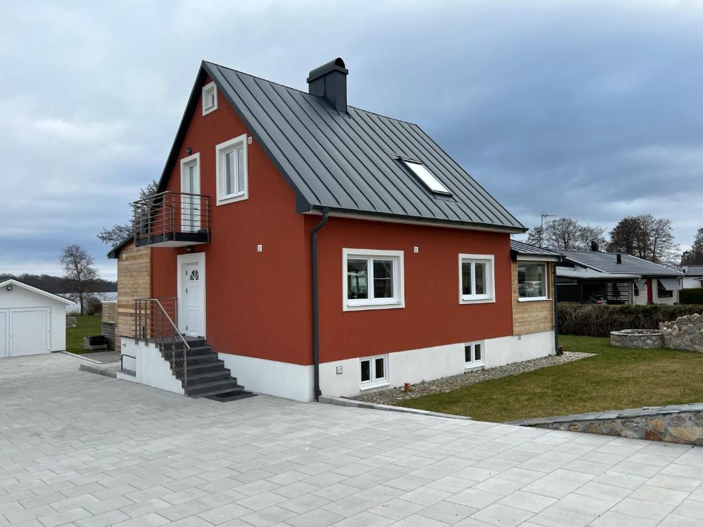 瑟尔沃斯堡Valjeviken的车道上黑色屋顶的红色房子