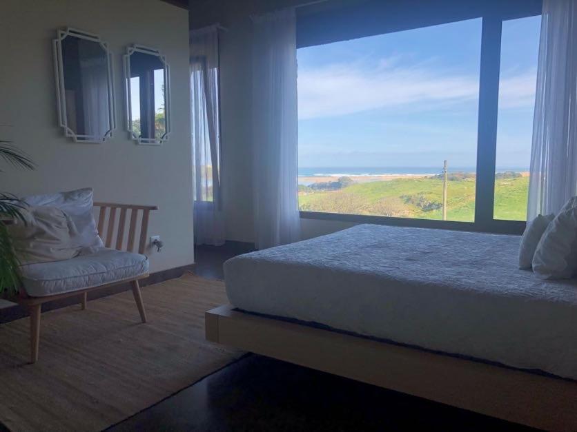 莫格罗La Carrera, Mogro Cantabria的一间卧室设有一张床和一个大窗户