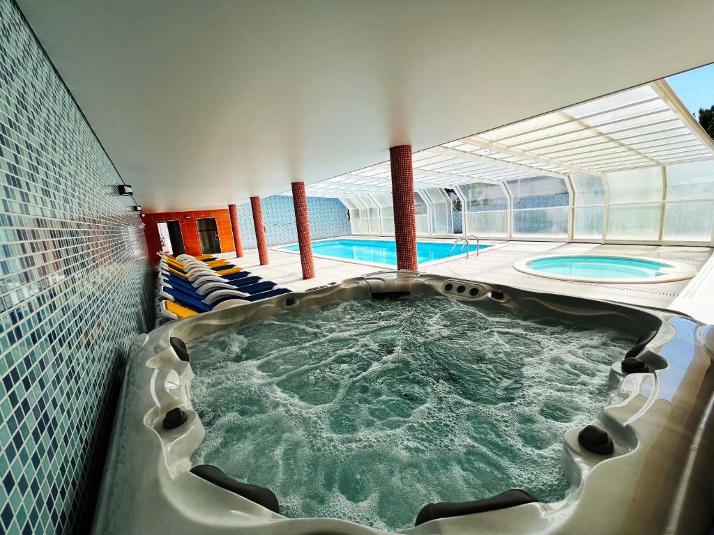 蒙特里尔Hotel Colmeia的一座大楼内带热水浴池的游泳池