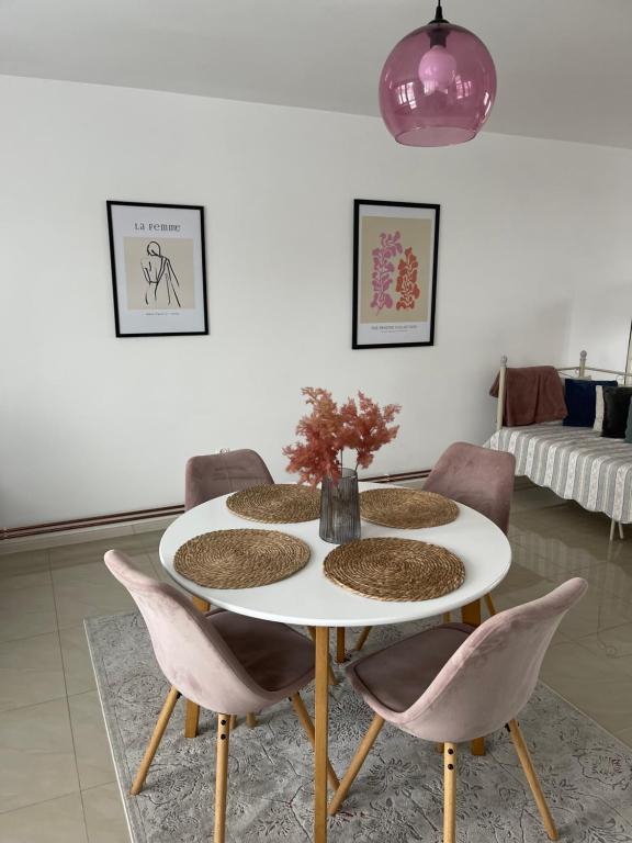 克罗斯诺Apartamenty Cud Miód的一间设有白色桌子和粉红色椅子的用餐室