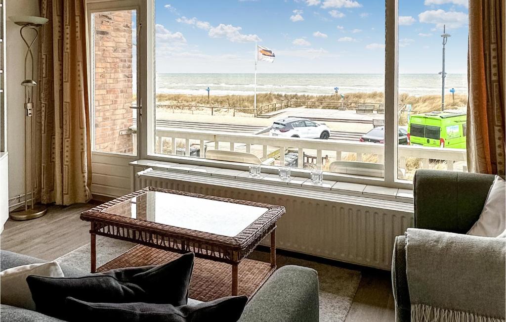 滨海贝亨Zwaluwnest的客厅设有桌子和大窗户