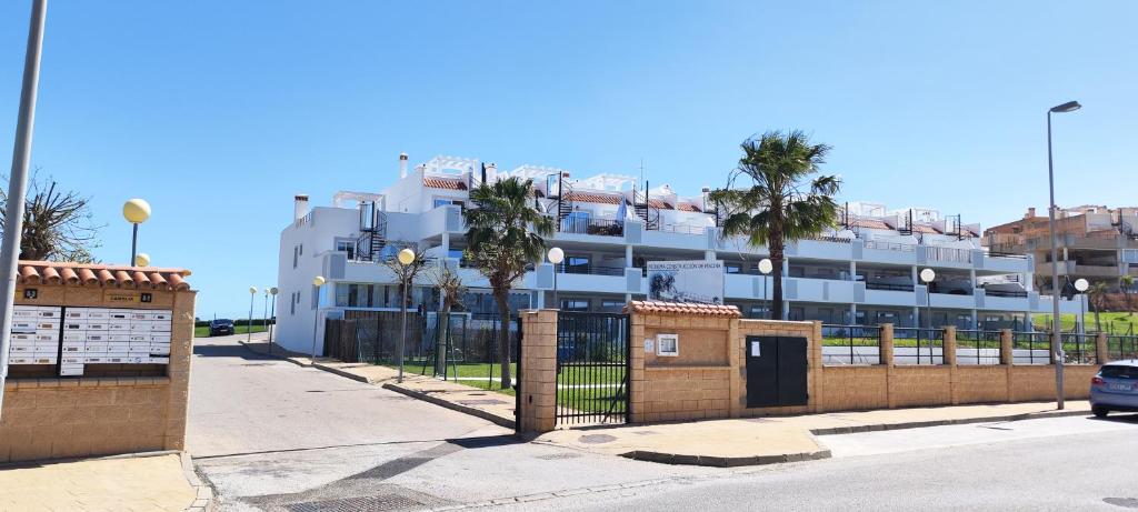 卡萨雷斯Casares Cozy Apartment的一座白色的大建筑,前面有棕榈树