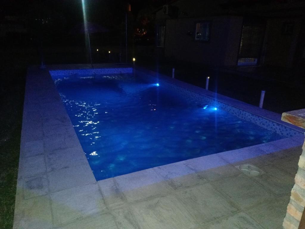 费德拉西翁Casa cabaña juanita的夜晚的游泳池,灯光蓝色