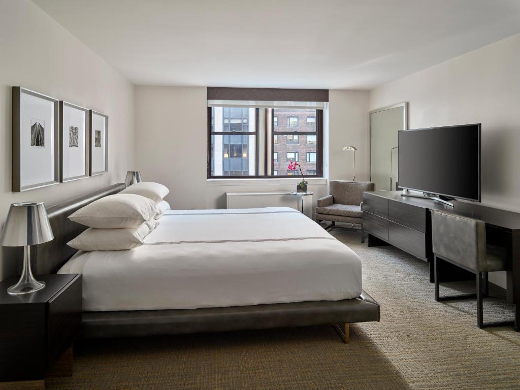 纽约AKA中央花园酒店的卧室配有一张白色大床和电视。