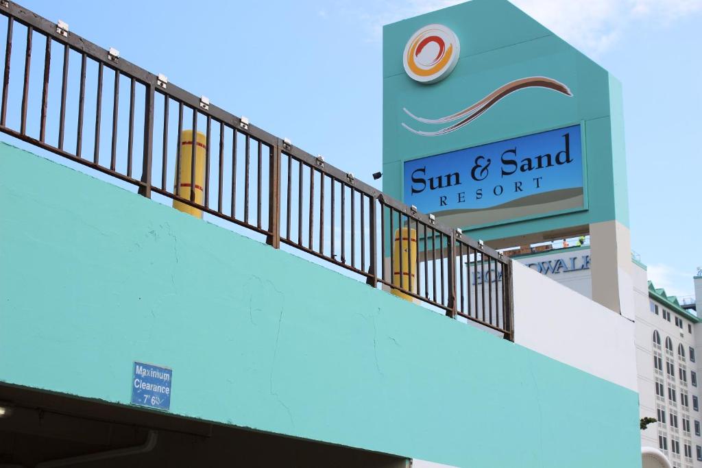 弗吉尼亚海滩Sun & Sand Resort Oceanfront Suites的建筑上太阳和沙地的标志