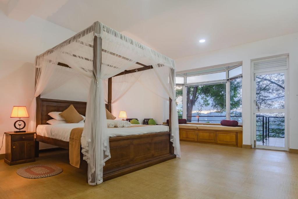 康提Villa Mount Melody的一间卧室设有一张天蓬床和大窗户