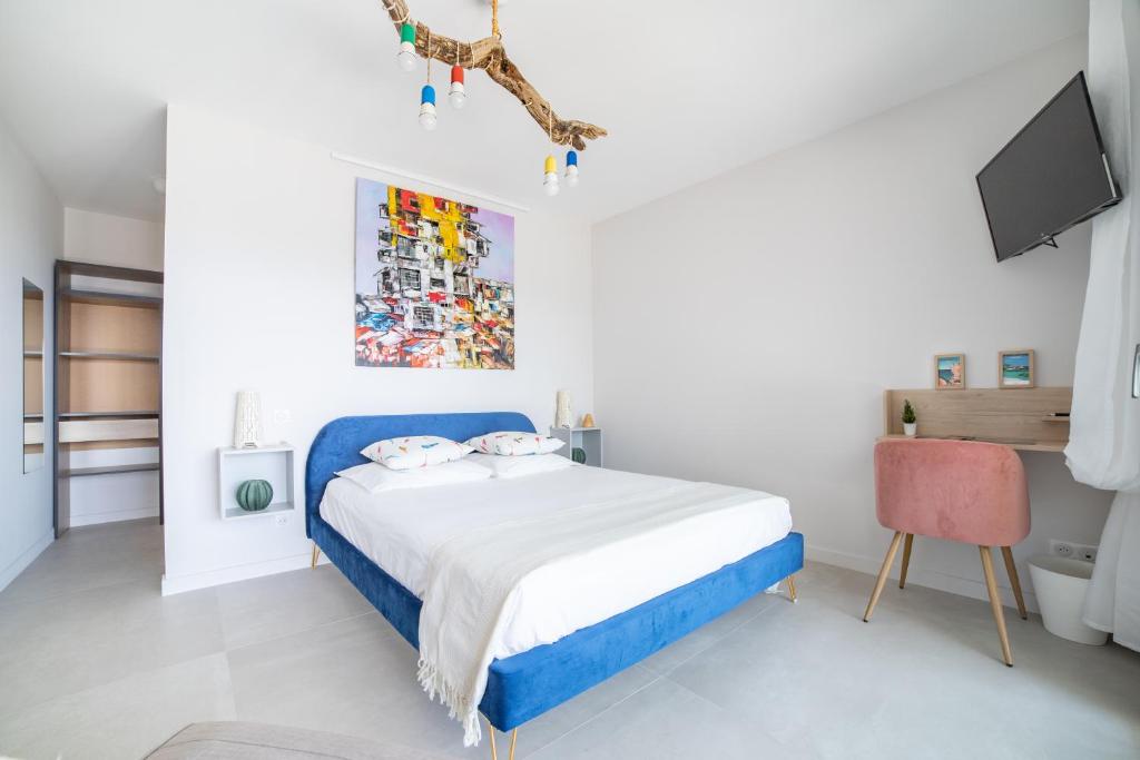 阿雅克修CASA LC chambre1 vue Mer Jacuzzi的白色卧室配有蓝色的床和电视