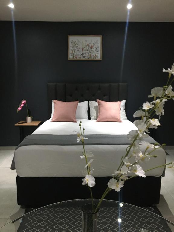 索韦托Black Rose Guesthouse的卧室配有一张带粉红色枕头的大床
