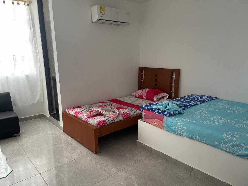 库库塔Américas al límite的一间卧室设有两张单人床和一个窗户。