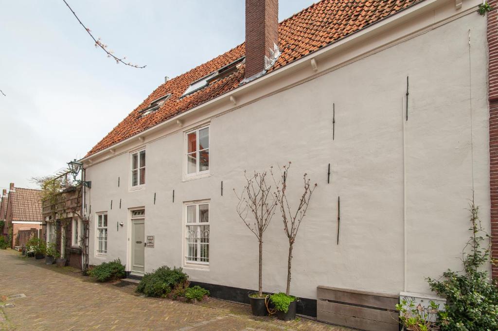 阿尔克马尔CASASdeCASPER - Apartment Alkmaar的街道旁的白色建筑,树