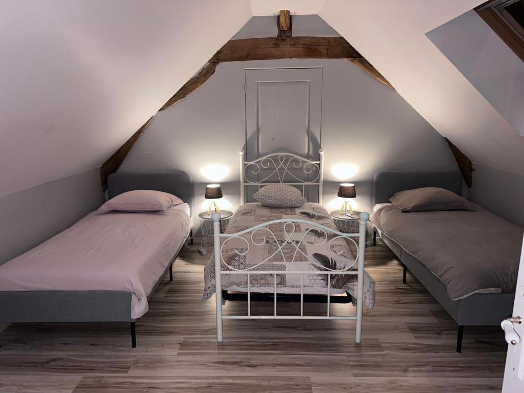 Cré-sur-LoirGîte la grande racinaie的阁楼上的卧室配有两张床