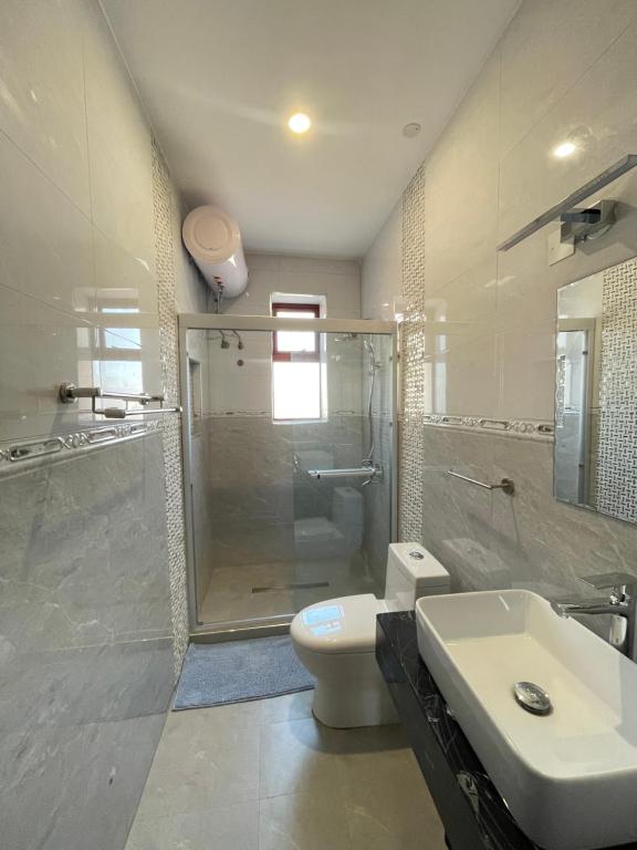坎帕拉Keitylin Heights Apartments in Makindye的带淋浴、卫生间和盥洗盆的浴室