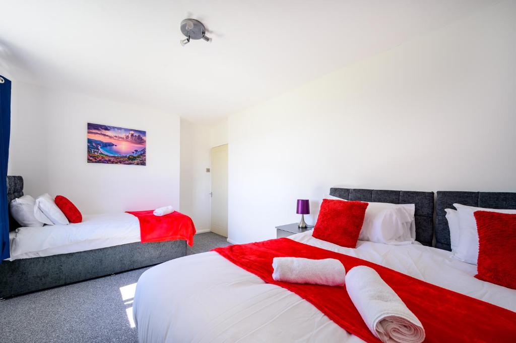 曼彻斯特Starview Apartment-Manchester Airport的一间卧室配有两张带红白色枕头的床