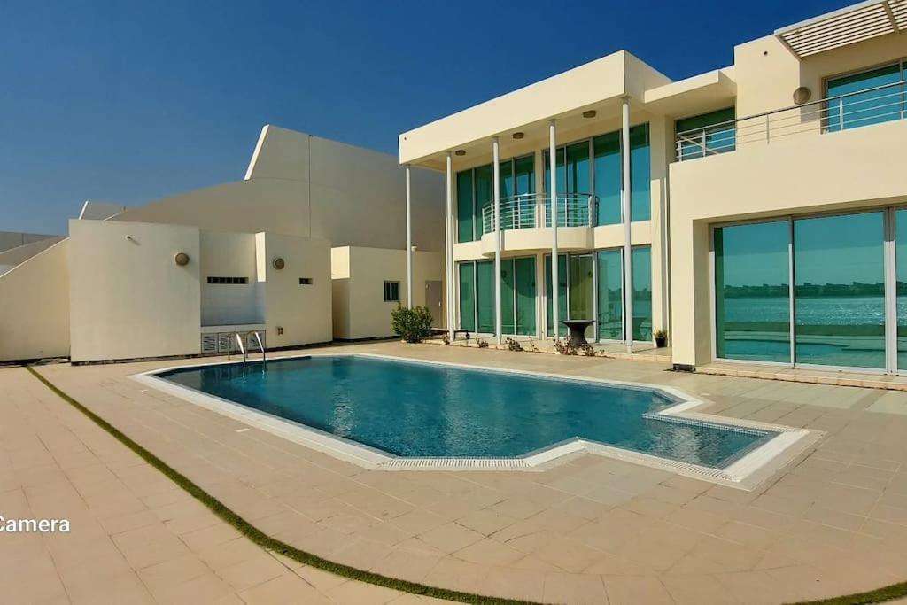 Durrat Al BahrainFamily friendly house in Bahrian的一座房子前面设有游泳池